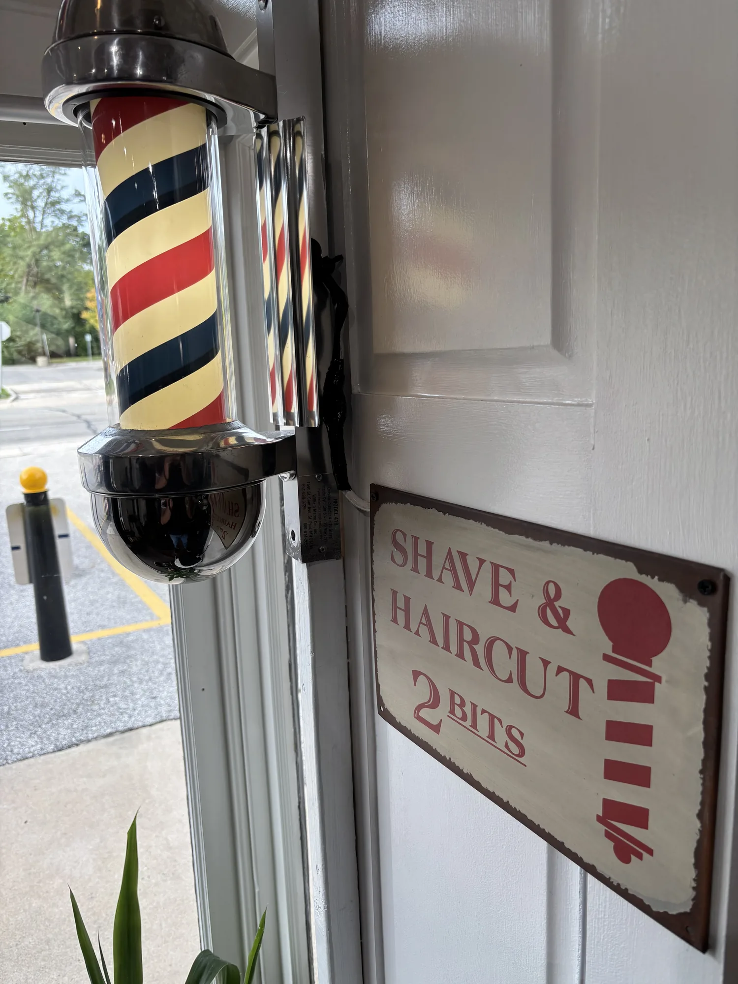 Barber pole by the door, with a Shave & Haircut 2 Bits sign